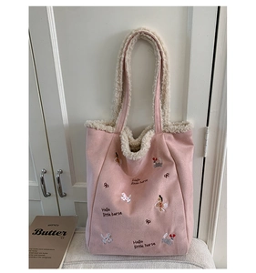 Dettaglio borsa tote in finta pelle scamosciata rosa con finiture in lana e ricami