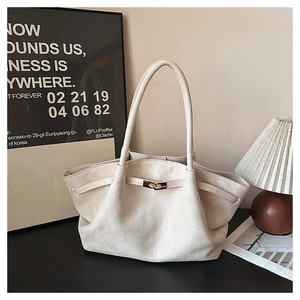 Detail of beige suede tote bag featuring elegant golden twist-lock and long shoulder straps
