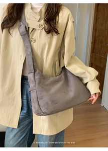 Detail of grey suede hobo bag showing wide shoulder strap and adjustable round buckle