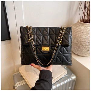Détail du sac bandoulière matelassé noir avec fermoir doré et bandoulière chaîne