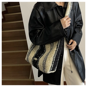 Close-up of fuzzy lamb wool tote bag with handmade label and striped winter texture
