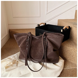 Détail du grand sac cabas marron vintage avec texture rétro sur une veste blanche