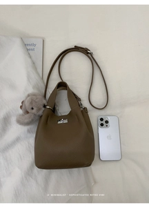 Detail of retro leather bucket bag with silver lock and smartphone for size reference
