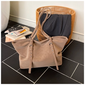 Detailed view of adjustable shoulder strap with silver metal buckle on coffee tote bag