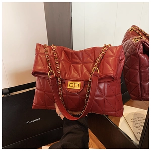 Vue macro d'un sac rouge matelassé en V avec chaîne dorée et fermoir pivotant en métal