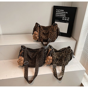 Three leopard print canvas tote bags with cute puppy plush charms on marble stairs