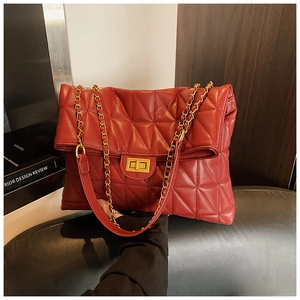 Détail du sac à bandoulière matelassé rouge foncé avec chaîne et fermoir dorés