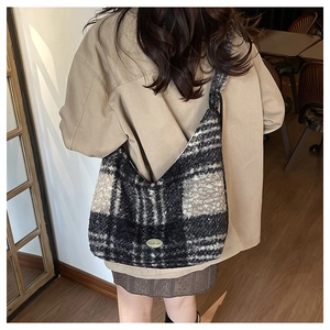 Detailed view of the winter plaid hobo bag with handmade metal plaque and plush texture