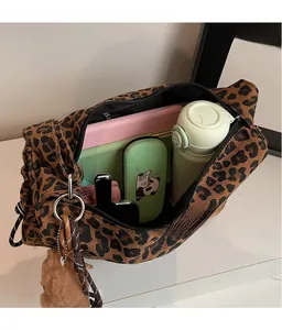 Spacious interior of leopard print shoulder bag with daily items and plush bear charm