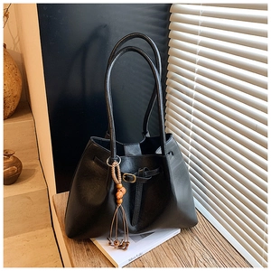 Détail d'un grand sac cabas noir vintage avec pampille bohème et boucle métallique élégante