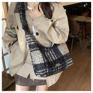 Detail of plush knit texture and metal logo on checkered winter hobo tote bag