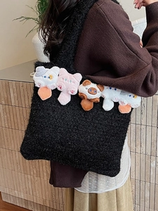 Black plush tote bag with cute 3D stuffed cat heads carried by a model on shoulder