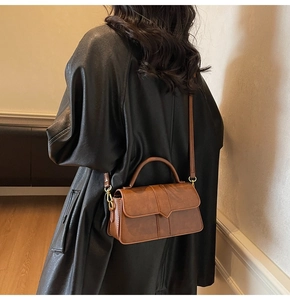 Petit sac vintage marron avec coutures en V et boucles métalliques dorées sur le côté