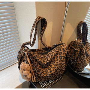 Détail du sac bandoulière léopard avec pendentif ours en peluche et sangle ajustable