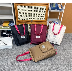 Sacs à dos en nylon noir, bordeaux, beige et kaki avec des poignées rose vif en groupe