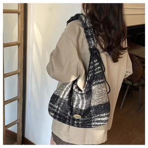 Detailed view of plush checkered tote bag with golden handmade logo and soft wool texture