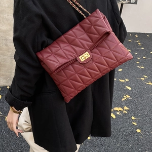 Détail du sac cabas en cuir matelassé bordeaux avec chaîne dorée et fermoir pivot