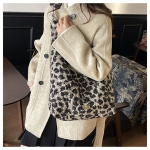 Detailed view of the leopard print plush texture and metal logo plaque on the tote bag