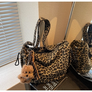 Détail du sac cabas en toile léopard avec un pendentif chien en peluche marron