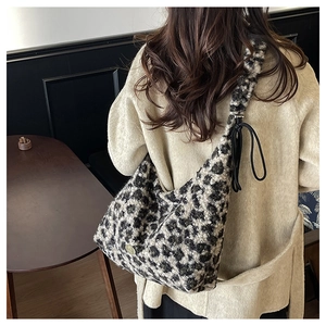 Macro view of leopard print plush tote bag showing detailed faux fur texture and black drawstring