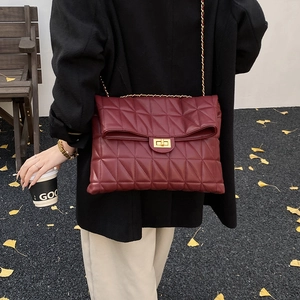 Détail du sac en cuir matelassé bordeaux avec chaîne dorée et fermoir rotatif