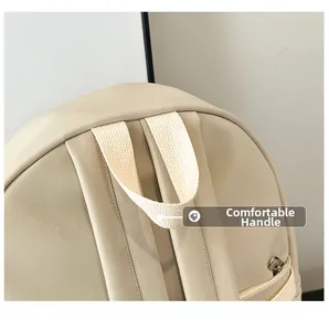 Close-up of beige leather backpack showing durable fabric handle and reinforced stitching
