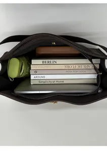 Top view of large capacity dark brown tote bag showing spacious interior with laptop and books