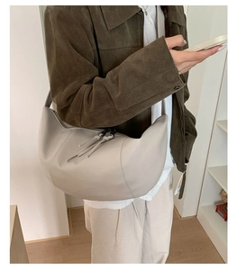 Dettaglio della grande borsa hobo beige in pelle PU con tirazip e design a pannelli