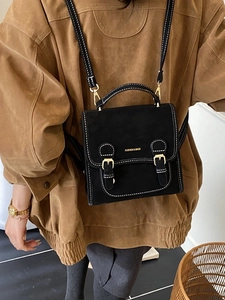 Retro black backpack with white contrast stitching and gold buckles for stylish women