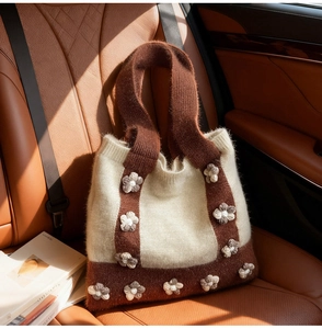 Close-up of handmade knit tote bag with 3D floral accents and brown textured stitching
