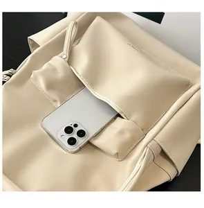 Detail view of the large front zipper pocket on beige PU leather backpack