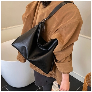 Πλάγια όψη μιας μεγάλης μαύρης vintage τσάντας tote φορεμένη από ένα μοντέλο