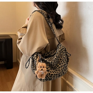 Sac fourre-tout léopard avec breloque chien en peluche porté sur un trench-coat kaki
