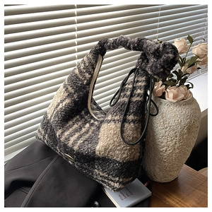 Detailed view of the fuzzy plaid tote bag featuring a knotted handle and soft texture