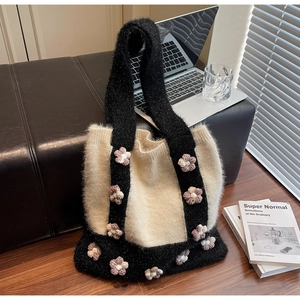 Détail du sac cabas en tricot avec fleurs 3D et texture douce en fil noir et blanc