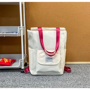 Détail du sac à dos pour ordinateur blanc crème avec sangles rouges et étiquette de mode
