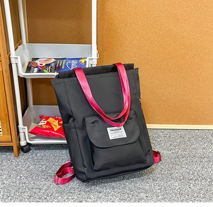 Détail du sac à dos pour ordinateur noir avec sangles roses et étiquette mode tendance