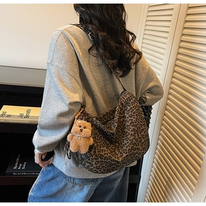 Détail d'un sac fourre-tout léopard tendance avec un pendentif d'ours en peluche mignon