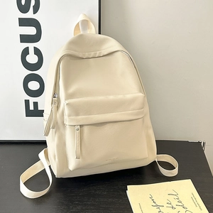 Close-up of minimalist beige PU leather backpack with front flap pocket and fabric handle
