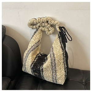 Detail of plush faux shearling tote bag featuring black and beige striped texture
