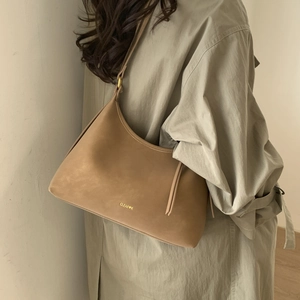 Detail view of a vintage brown leather hobo bag with a gold buckle and brand logo