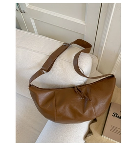 Dettaglio della trama della borsa hobo in ecopelle marrone su morbido pile bianco