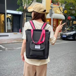 Détail du sac à dos nylon noir et rouge avec étiquette Fashion Instinct et poche