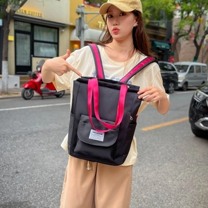 Sac à dos d'étudiant noir avec bretelles roses porté par un mannequin féminin