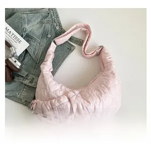 Detailed close-up of pink heart-quilted shoulder bag with adjustable strap and sleek texture