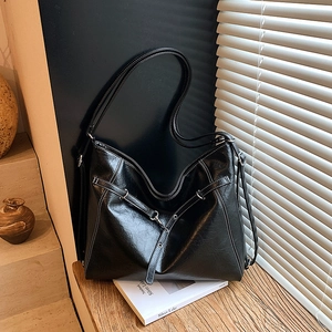 Detailaufnahme der glänzenden schwarzen Hobo-Tasche mit Kontrastnähten und Silberbeschlägen