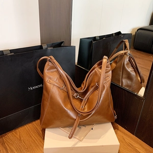 Detail einer braunen Leder-Tote-Bag mit Kontrastnähten und verstellbarem Schultergurt