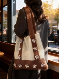 Chic knitted tote bag with floral accents and soft shoulder strap in beige and brown