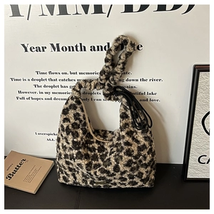 Detail showing the fluffy leopard print lamb wool texture and scrunchie handle of the hobo bag