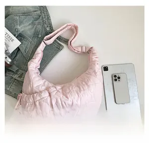 Pink heart quilted crescent bag shown next to a tablet and phone for size reference